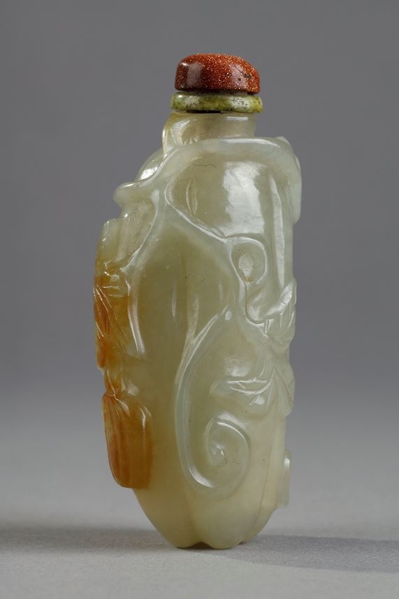 Celadon green nephrite jade snuffbottle in the shape of .pumpkin with its leaves and another small fruit in a reddish brown inclusion - China 19th century | MasterArt